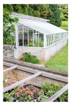 A greenhouse and garden beds at Millbourne Estate