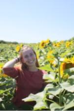 Sarah Skane poses for a photo in a field of sunflowers