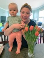 Kristen Guerreri poses for a photo with her baby, beside a vase full of tulips