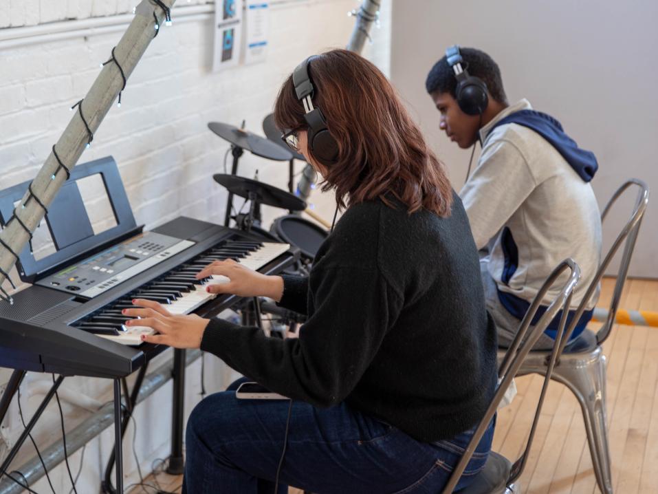 Kim Bautista Ruiz plays a piano keyboard next to another person