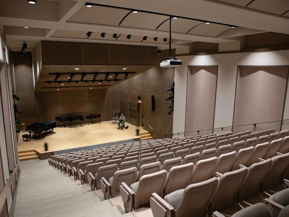 A large empty auditorium looking down at the wood floor of the stage. 