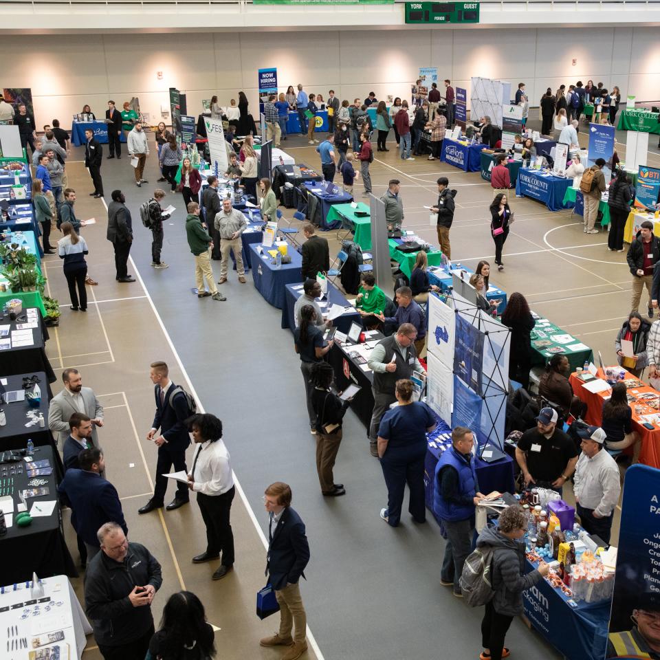 View of the YCP Career Expo from above. Many people are interacting at tables lined up in a large room.