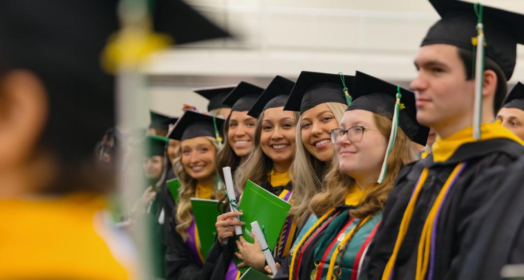 A group of girls smiles at the camera for Spring Commencement