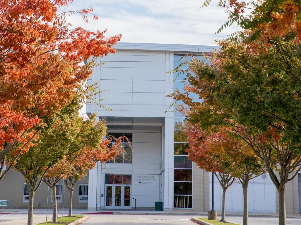 An exterior photo of Grumbacher with fall leaves lining the road.