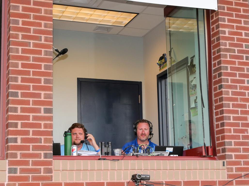 Darrell Henry sits in the broadcasting booth at Rev's Stadium, working during a game.