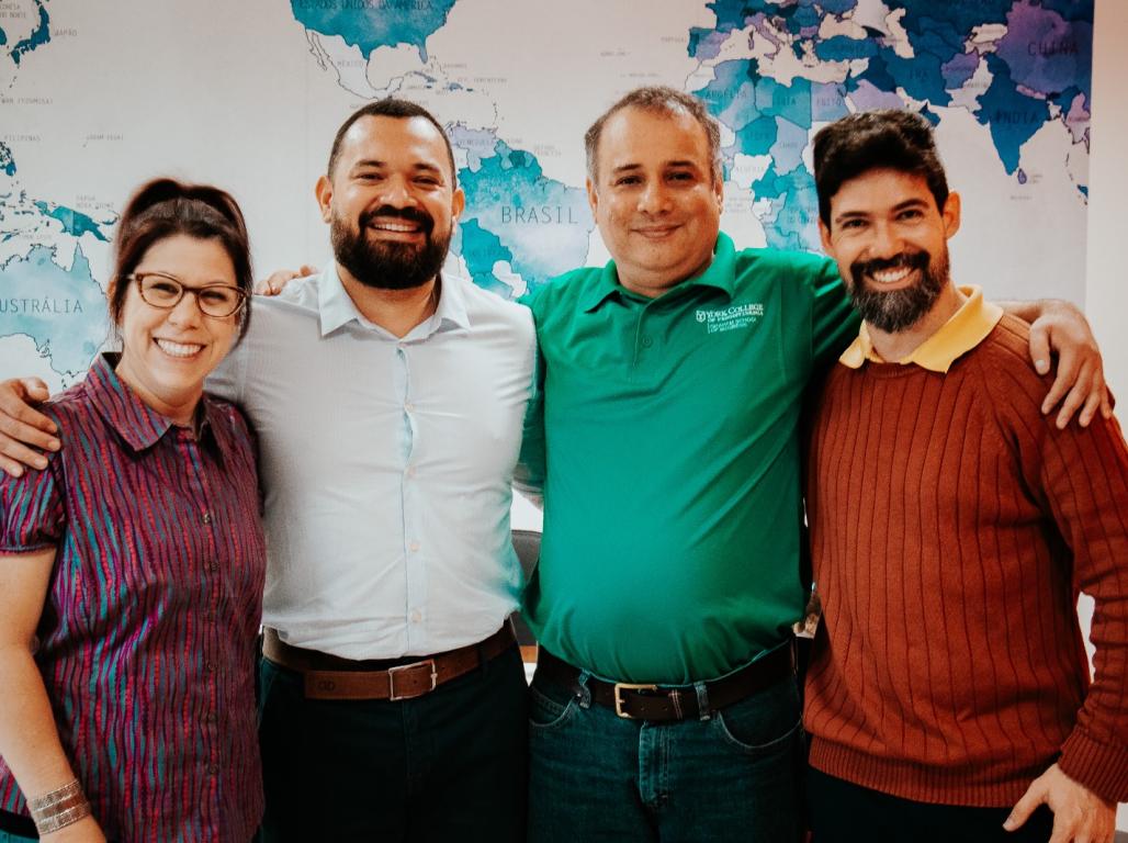 Drs. Tamara Sniad and Mohammed Raja stand together with two collaborators in front of a map