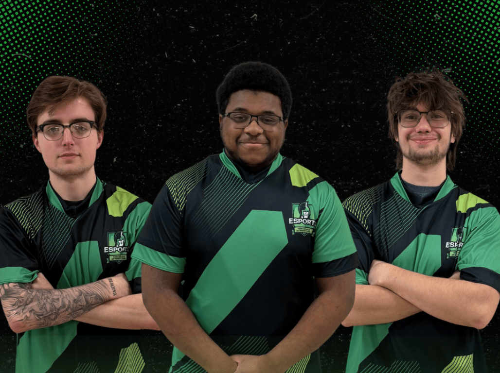 Three ESports students stand in their uniforms together with a graphic that reads Battle of the Atlantic