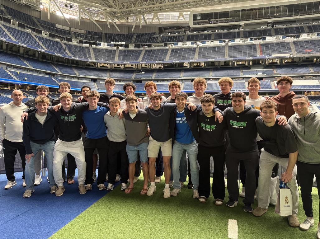 The YCP soccer team poses for a group photo in a large sports arena in Spain.