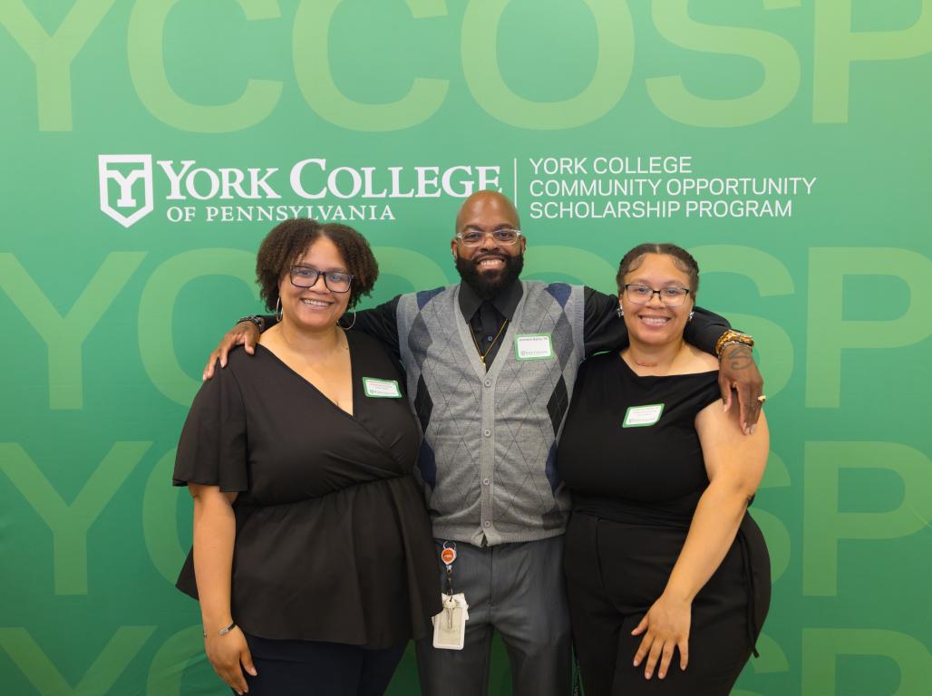 Three people pose in front of a banner that reads York College Community Opportunity Scholarship Program (YCCOSP))