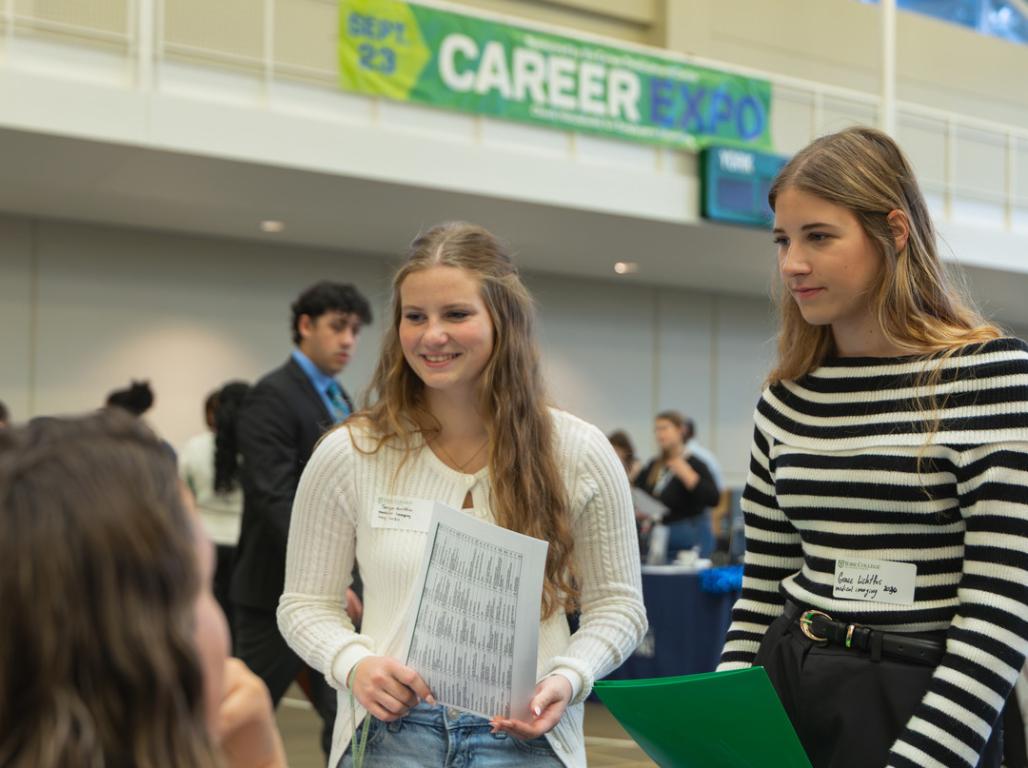 Two students speak to an employer at the career expo.