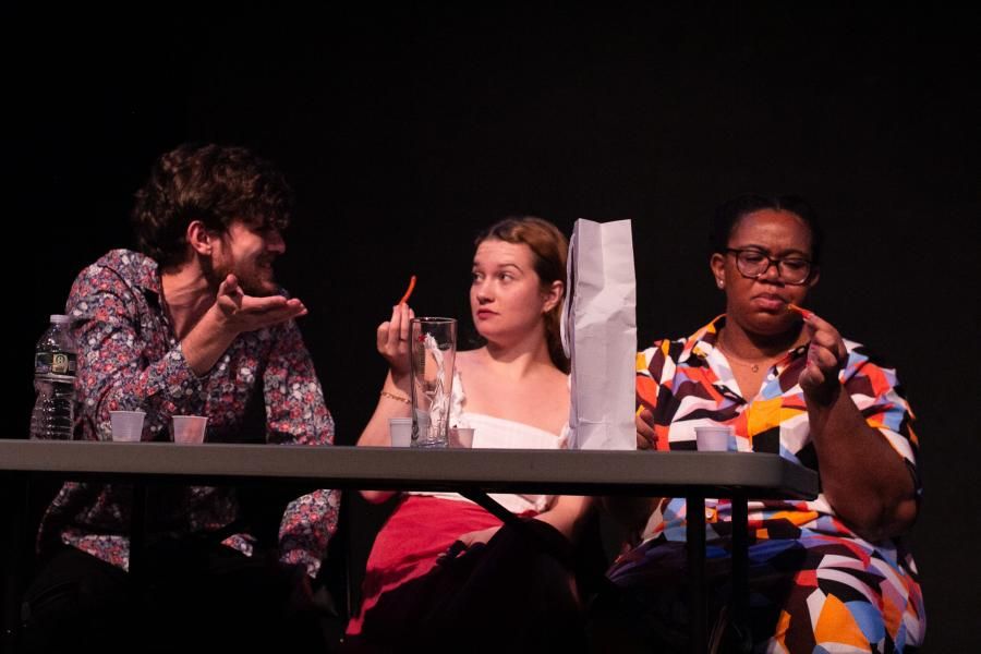 Three people acting in a stage play.