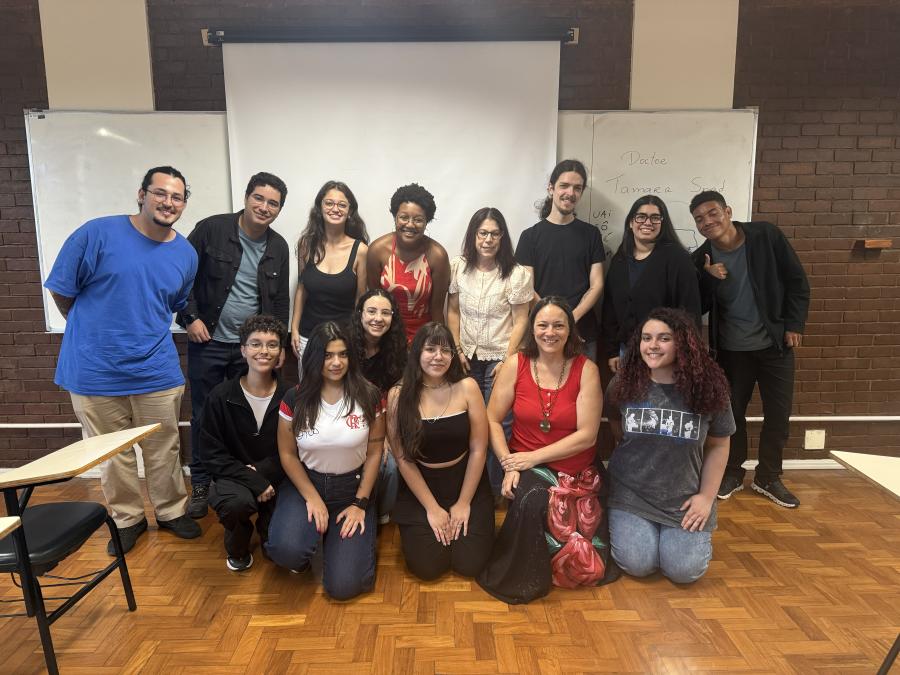 A group of students pose for a photo in the front of a classroom