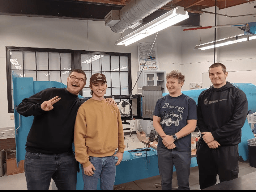 Four students standing in an engineering lab.