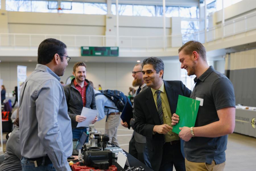 A group of people engaged in lively conversation at the Spring 2026 York College Career Expo.
