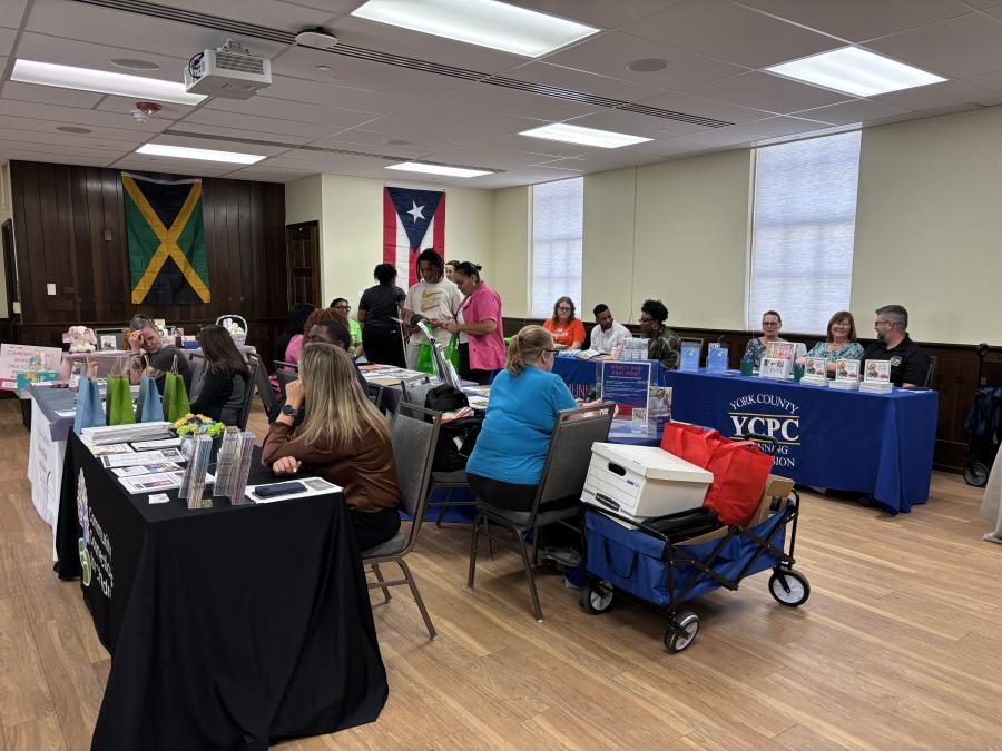 A large room set up with tables with baby supplies. 