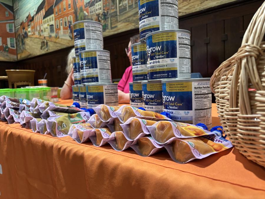 A table lined up with stacked baby supplies.