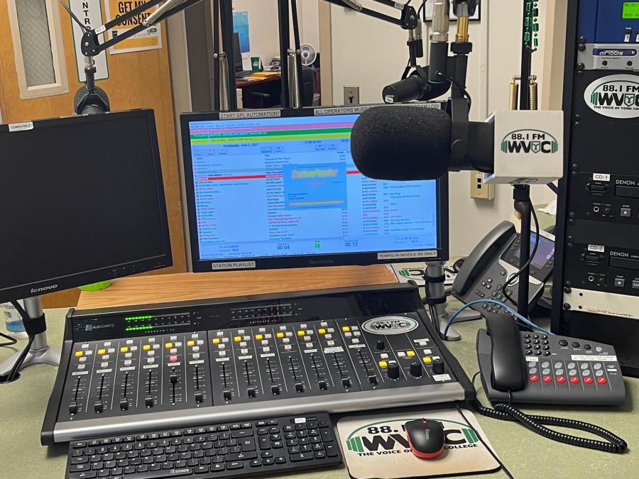 WVYC radio studio featuring microphones, a soundboard, computer monitors, and 88.1 FM WVYC branding.