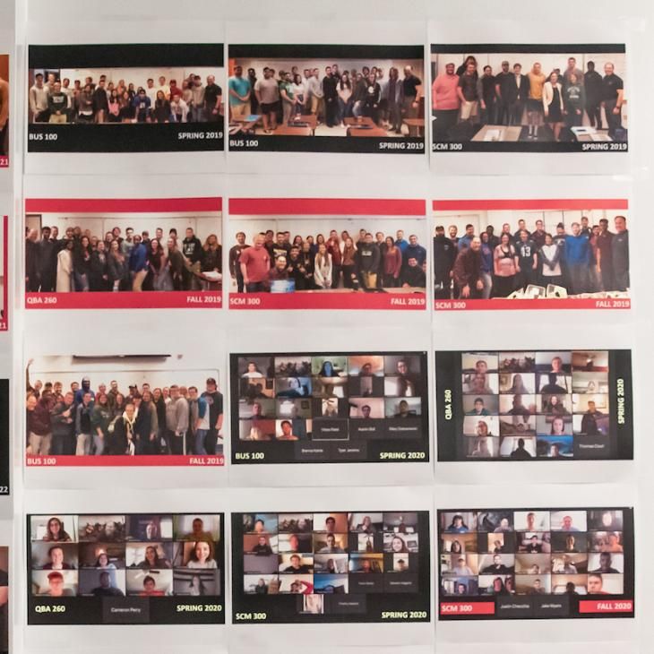 A series of 12 group photos hang on a wall.