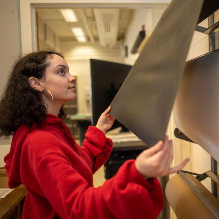A York College of Pennsylvania student examines paper on an industrial roll.