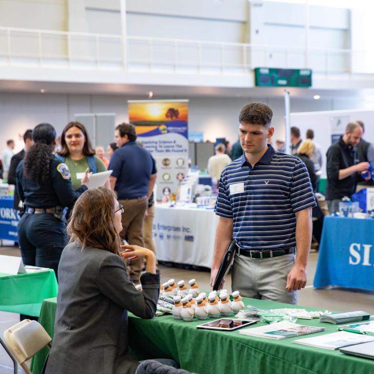 Several people are visible having separate conversations at a professional networking event.