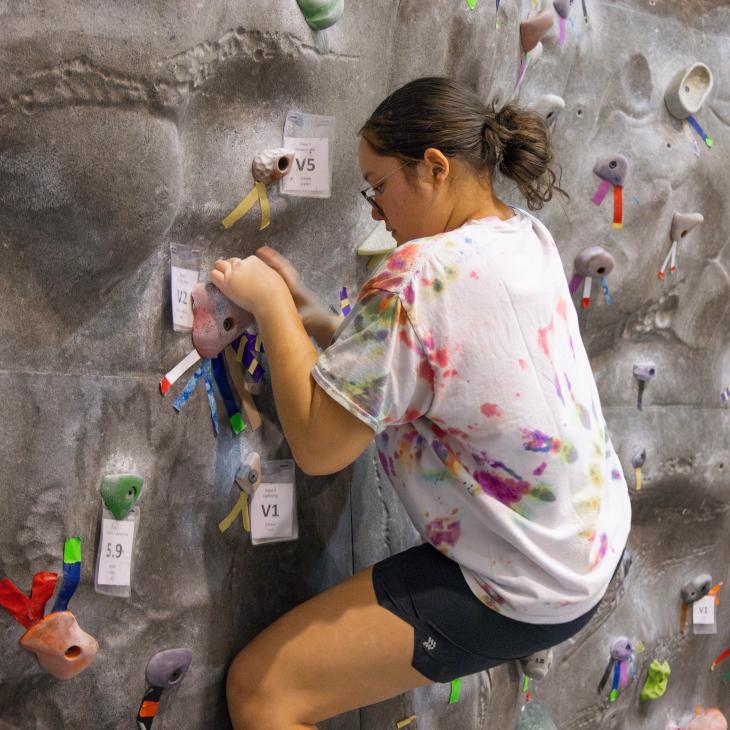 Rock climber in the middle of a climb.