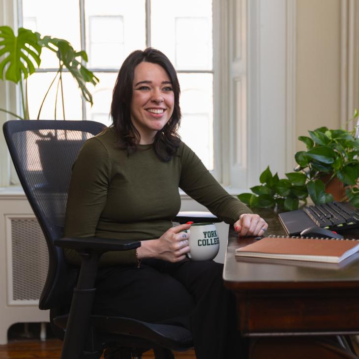 A graduate student sitting at a computer desk.