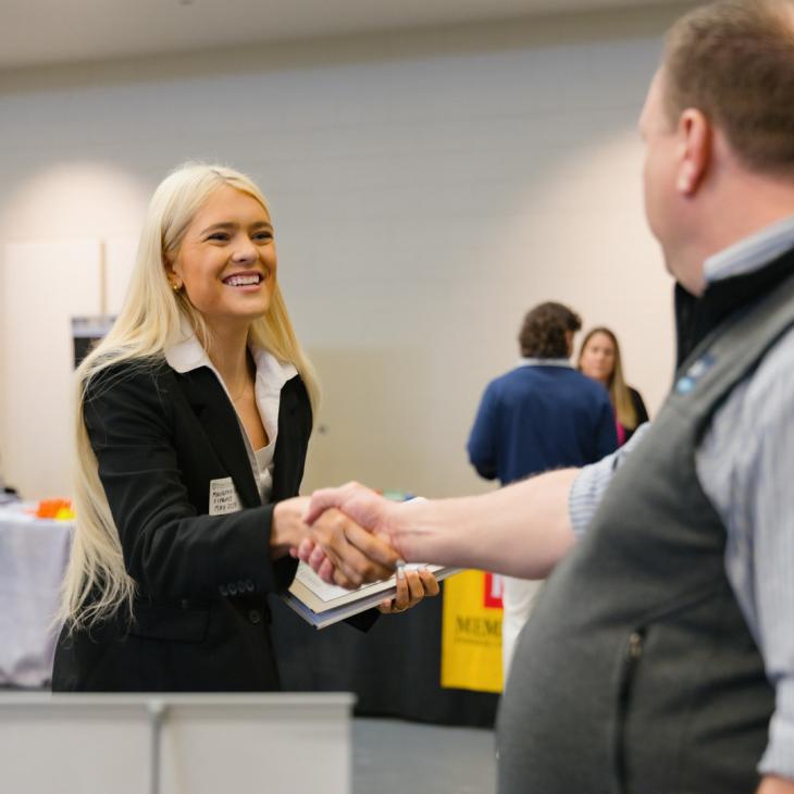 Student shakes hands with potential employer at Career Expo.
