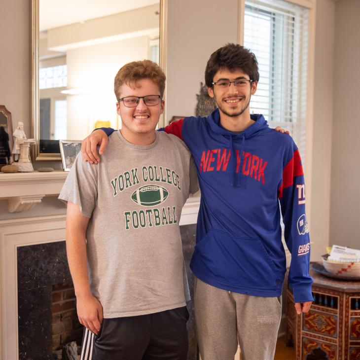 2 students smiling for a photo with arms around each other